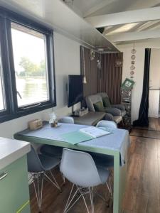 莱茵河畔阿尔芬Aangenaam op de Rijn, woonboot, inclusief privé sauna的一间带桌椅的房间和一间客厅