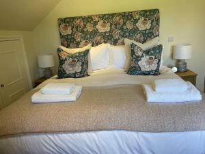 法纳姆Cottage 2, Northbrook Park, Farnham-up to 6 adults的一张大床,配有两个枕头和毛巾