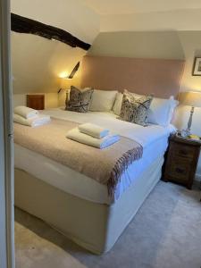 法纳姆Cottage 2, Northbrook Park, Farnham-up to 6 adults的一间卧室配有一张大床和毛巾