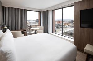 格拉斯哥AC Hotel by Marriott Glasgow的一间酒店客房,设有一张大床和一个大窗户