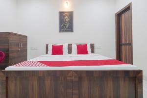 卢迪亚纳OYO Hotel Bella Ciao的一间卧室配有一张带红色枕头的大床