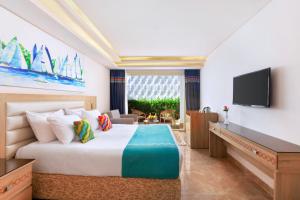 沙姆沙伊赫Pickalbatros Palace Sharm - "Aqua Park"的配有一张床和一台平面电视的酒店客房