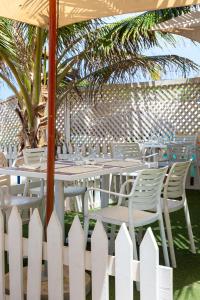 达喀尔拉马德拉戈 - 冲浪海滩碧海酒店的一张带白色椅子的桌子和白色围栏