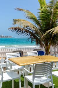 达喀尔拉马德拉戈 - 冲浪海滩碧海酒店的海滩旁的一张木桌和椅子