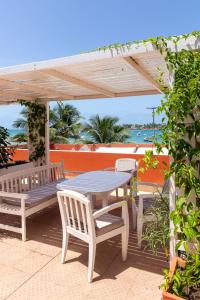 达喀尔拉马德拉戈 - 冲浪海滩碧海酒店的木凉棚下的野餐桌和椅子