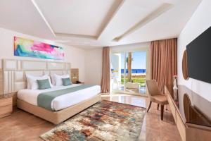 沙姆沙伊赫Pickalbatros Palace Sharm - "Aqua Park"的酒店客房,配有床和电视