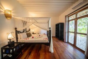 吉汶瓦Beachfront Turtle House ZanzibarHouses的一间卧室配有一张带天蓬的床