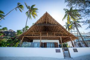 吉汶瓦Beachfront Turtle House ZanzibarHouses的棕榈树海滩上的竹楼