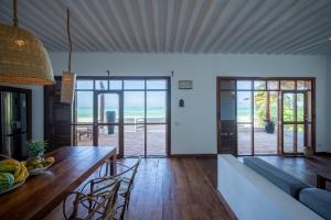 吉汶瓦Beachfront Turtle House ZanzibarHouses的厨房以及带桌子和沙发的客厅。