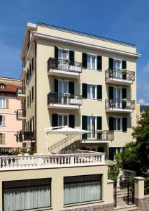 阿拉西奥Residence San Marco Suites&Apartments Alassio的公寓大楼设有阳台,享有蓝色的天空