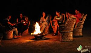 瑞诗凯诗Aspen Adventures Camp by Aspen的一群人围坐在火炉旁