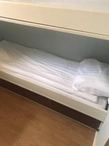 斯德哥尔摩古斯塔夫克林特船屋的双层床配有白色床单和枕头