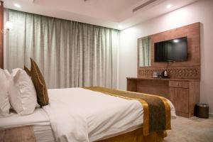 吉达Areen Hotel Al Basateen的配有一张床和一台平面电视的酒店客房