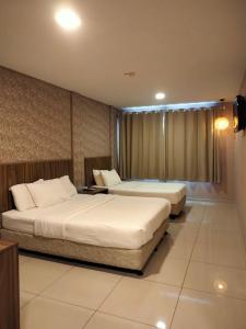劳勿哲莱酒店@劳勿，彭亨的酒店客房设有两张床和电视。