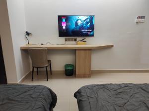 话毛生Hanan Studio Apartment with Pool, Wifi & Netflix的客房设有一张桌子,墙上配有电视
