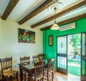 埃尔博斯克2 bedrooms house with private pool and terrace at El Bosque的一间拥有绿色墙壁和桌椅的用餐室