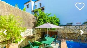 埃尔博斯克2 bedrooms house with private pool and terrace at El Bosque的一个带桌子和遮阳伞的庭院,毗邻一个游泳池