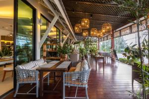 蔻立Phukhaolak Resort的餐厅设有桌椅和窗户。