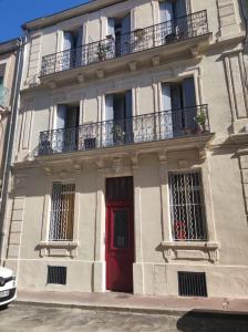 蒙彼利埃Appartement 2 pièces Montpellier centre的白色的建筑,有红色的门和窗户