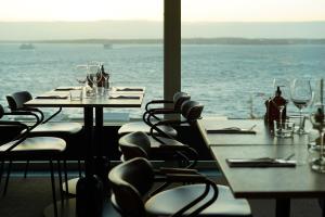 赫尔辛堡Clarion Hotel Sea U的一间设有桌椅的海景餐厅