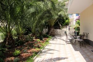 斯普利特Apartment LU的一个带桌椅的庭院,棕榈树
