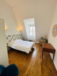 日安L'Herboriste - Appartements meublés的一间卧室配有一张床,铺有木地板