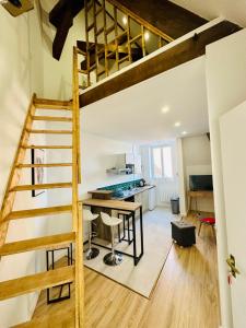 日安L'Herboriste - Appartements meublés的阁楼转换的厨房和带阁楼梯子的用餐室