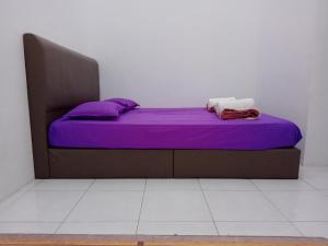双溪大年Wany Homestay Free Wifi And Astro NJOI的一张位于带紫色床单和枕头的客房的床铺