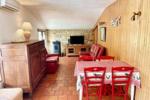 GardonneGite de charme en pierres apparentes : Les Granges的一间带桌子和红色椅子的用餐室