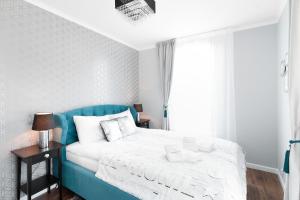 克拉科夫2- bedroom Apartment Premium Masarska by Renters Prestige的卧室配有蓝色和白色的床和窗户。