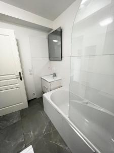 谢西Design Apartment Disneyland Paris的白色的浴室设有浴缸和水槽。