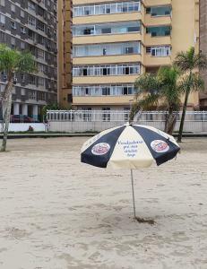 桑托斯Aqui é pé na areia的沙滩上的蓝白遮阳伞
