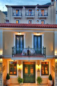 特尔斐阿尔特弥斯酒店的一座带绿门和阳台的建筑