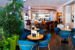 罗什福尔Hôtel & Restaurant des Remparts的一间设有蓝色椅子的餐厅和一间酒吧