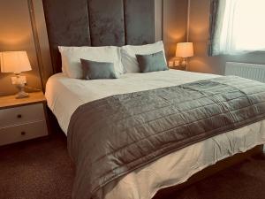 新罗姆尼Pass the Keys Luxury Lakeside Lodge的一间卧室配有一张大床,设有两个床头柜和两盏灯