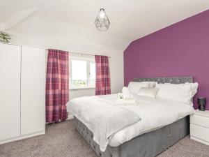 利兹Pass the Keys Large Family Getaway的一间卧室设有紫色的墙壁和一张大床