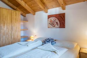 科尔皮缇亚Tschigghof的卧室配有一张床,墙上挂有绘画作品