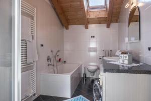 科尔皮缇亚Tschigghof的带浴缸、卫生间和盥洗盆的浴室