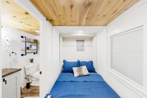 Mills RiverCozy Lakeview Cottage的小房子里的小卧室里设有一张蓝色的床
