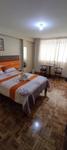 利马Aruba Suite Hotel的一间卧室配有一张大床和一张桌子