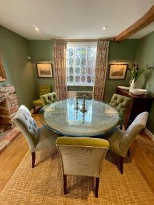 法纳姆Northbrook Cottage, Farnham, up to 8 adults的一间设有玻璃桌和椅子的用餐室