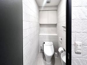东京Shibuya Harajuku big house的白色的浴室设有卫生间和水槽。