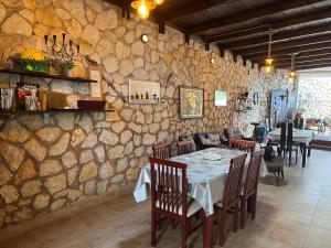 阿约斯尼奇塔斯拉卡萨德艾琳旅馆 的一间设有桌子和石墙的用餐室