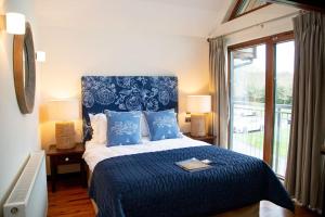 法纳姆Azalea Northbrook Park Chalet的卧室配有蓝色和白色的床,设有窗户