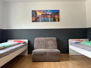 波鸿Modernes Apartment 5 , 6 und 7 in Bochum的一间设有两张床和椅子的房间