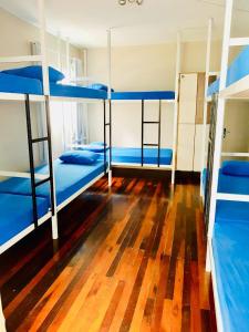 弗洛里亚诺波利斯Pousada & Hostel Mar dos Ingleses的客房设有三张双层床,铺有木地板。