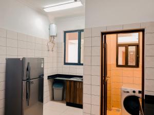 达累斯萨拉姆Elles Residence的厨房配有不锈钢冰箱和窗户