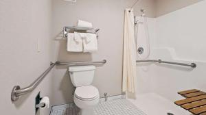 洋滨市Lighthouse Suites Inn的浴室设有卫生间和带毛巾的淋浴。