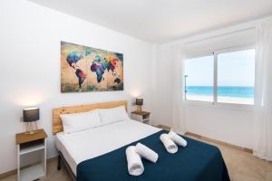 福恩吉罗拉Madeinterranean Beach- Higueron Front Line Apartment的一间卧室设有一张床和一个窗户,享有海景