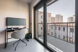 莱比锡YUMA Apartments Leipzig Berliner Straße的一个带书桌和大窗户的办公室